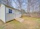 A backyard storage shed with a ramp for easy access and windows for ventilation, set on a green lawn at 8353 Emily Dr, Harrisburg, NC 28075