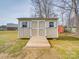 Backyard storage shed with ramp, windows, and double doors, surrounded by a green lawn at 8353 Emily Dr, Harrisburg, NC 28075