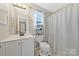 Bright bathroom with white vanity, toilet, and shower with updated fixtures and natural lighting at 8701 Gainsford Ct, Charlotte, NC 28210