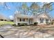Inviting one-story home with a front porch, driveway, and lush greenery creating an attractive entryway at 8701 Gainsford Ct, Charlotte, NC 28210