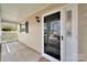 A welcoming front porch featuring a screen door, sidelight, and neutral color scheme at 8701 Gainsford Ct, Charlotte, NC 28210