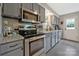 Modern kitchen with stainless steel appliances, gray cabinets, and sleek granite countertops at 8701 Gainsford Ct, Charlotte, NC 28210