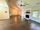 Living room featuring a painted brick fireplace, ceiling fan, and wood-look flooring at 8723 Totteridge Dr, Charlotte, NC 28277