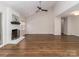 Living room featuring a painted brick fireplace, ceiling fan, and wood-look flooring at 8723 Totteridge Dr, Charlotte, NC 28277
