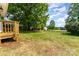 Expansive backyard featuring a deck, lush green lawn, and mature trees providing ample shade and privacy at 110 Walters St, Huntersville, NC 28078