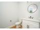 New half bathroom features a modern vanity and designer round mirror at 110 Walters St, Huntersville, NC 28078