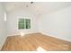 Well-lit bedroom with wood-look flooring, large windows offering natural light, and fresh white walls at 110 Walters St, Huntersville, NC 28078