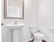 This powder room offers a pedestal sink and toilet with hardwood flooring at 1113 Foxberry Ln, Maiden, NC 28650
