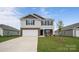 Charming two-story home featuring stone accents, a two-car garage, and a well-manicured lawn at 1113 Foxberry Ln, Maiden, NC 28650