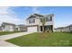 Charming two-story home featuring stone accents, a two-car garage, and a green lawn at 1113 Foxberry Ln, Maiden, NC 28650