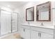 Bathroom featuring dual sinks, framed mirrors, white cabinets, shower with glass enclosure and tile floor at 1117 Foxberry Ln, Maiden, NC 28650