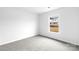Neutral bedroom featuring carpeted floors and window with view of the neighborhood at 1117 Foxberry Ln, Maiden, NC 28650