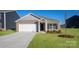 Charming brick home featuring a two-car garage, well-maintained lawn, and classic architectural details at 1129 Foxberry Ln, Maiden, NC 28650