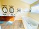 Bright bathroom with double vanity, large tub, and tile floors, offering a spa-like retreat for relaxation at 11307 Celandine Ct, Charlotte, NC 28213