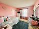 A cozy pink bedroom with a dresser, window, patterned rug, and decor for a personal touch at 11307 Celandine Ct, Charlotte, NC 28213