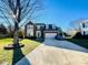 Charming two-story brick home with manicured lawn, long driveway, and attached two-car garage at 11307 Celandine Ct, Charlotte, NC 28213