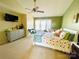 Bright main bedroom featuring a ceiling fan, gray dresser, a sitting area by the window, and a white crib at 11307 Celandine Ct, Charlotte, NC 28213