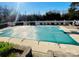 Backyard pool with a safety cover is surrounded by a white picket fence, patio and minimal landscaping at 11307 Celandine Ct, Charlotte, NC 28213