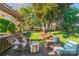 Back yard features a relaxing deck with wicker chairs, steel fire pit, and lush lawn at 12112 Autumn Winds Ln, Pineville, NC 28134