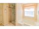 Bathroom featuring a glass enclosed shower and a soaking tub under a window at 12112 Autumn Winds Ln, Pineville, NC 28134
