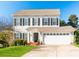 Charming two-story home with a well-manicured lawn, attached garage, and black shutters at 12112 Autumn Winds Ln, Pineville, NC 28134