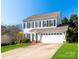 Charming two-story home featuring a well-manicured lawn, attached two-car garage, and classic black shutters at 12112 Autumn Winds Ln, Pineville, NC 28134