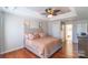 Comfortable main bedroom with a tray ceiling, ceiling fan, and hardwood floors at 12112 Autumn Winds Ln, Pineville, NC 28134