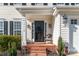 Cozy front porch area with brick steps, lantern lighting, and a charming chair at 12112 Autumn Winds Ln, Pineville, NC 28134