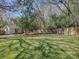 Large, grassy backyard with a wooden fence and a small outbuilding in the distance at 1225 Braeburn Rd, Charlotte, NC 28211
