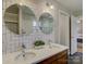 Bathroom featuring a double sink vanity, round mirrors, and subway tile backsplash at 1225 Braeburn Rd, Charlotte, NC 28211