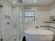 Modern bathroom with a sleek glass shower, soaking tub, subway tile walls and a window at 1225 Braeburn Rd, Charlotte, NC 28211