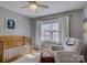 Cozy Bedroom with a wooden crib, comfortable armchair, and natural light from the window at 1225 Braeburn Rd, Charlotte, NC 28211
