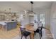 Bright dining area featuring wood table, chairs, and a modern light fixture, next to an open kitchen with stainless steel appliances at 1225 Braeburn Rd, Charlotte, NC 28211