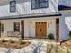 Inviting front porch featuring wooden pillars, double doors, and updated light fixtures at 1225 Braeburn Rd, Charlotte, NC 28211