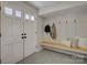 Well-lit mudroom with patterned tile flooring, a bench, and coat hooks at 1225 Braeburn Rd, Charlotte, NC 28211