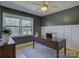 Well-lit home office featuring dark green walls, wainscoting, a wooden desk, and ample natural light at 1225 Braeburn Rd, Charlotte, NC 28211