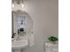 Stylish powder room with chevron wallpaper, round mirror, pedestal sink, and a glimpse into the adjacent kitchen at 1225 Braeburn Rd, Charlotte, NC 28211