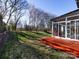 Enclosed backyard with spacious lawn, wooden deck and sunroom addition at 13807 Queenswater Ln, Charlotte, NC 28273