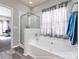 A bathtub with shower head and a white shower curtain is featured in this bathroom at 13807 Queenswater Ln, Charlotte, NC 28273