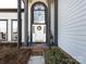 Close up of the doorway with an arched entrance, decorative wreath and potted plants at 13807 Queenswater Ln, Charlotte, NC 28273