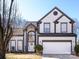 Charming two-story home with manicured lawn, arched entryway, two car garage, and gray and white trim at 13807 Queenswater Ln, Charlotte, NC 28273