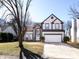 Charming two-story home with manicured lawn, arched entryway, two car garage, and gray and white trim at 13807 Queenswater Ln, Charlotte, NC 28273