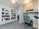 Home office with carpeted floor, built-in shelves, and a built-in desk at 13807 Queenswater Ln, Charlotte, NC 28273