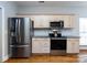 Updated kitchen featuring modern stainless steel appliances, light wood cabinets, and subway tile backsplash at 13807 Queenswater Ln, Charlotte, NC 28273