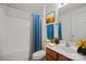 Bright bathroom featuring a shower-tub combo with sleek fixtures, and a cherry-stained wood vanity with decorative accents at 140 N Arcadian Way, Mooresville, NC 28117