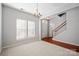 Comfortable living room with a modern chandelier, natural light, and stairway access at 140 N Arcadian Way, Mooresville, NC 28117
