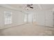 Airy bedroom with tray ceiling, fan, and ensuite bathroom entrance at 140 N Arcadian Way, Mooresville, NC 28117