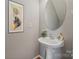 Stylish powder room boasts a pedestal sink and modern fixtures, complemented by elegant art and a decorative mirror at 140 N Arcadian Way, Mooresville, NC 28117