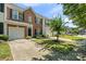 Well-maintained brick townhome featuring an attached garage, lush lawn, and mature landscaping at 140 N Arcadian Way, Mooresville, NC 28117