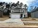 Charming two-story home featuring a two-car garage, gray siding, and beautifully landscaped front yard at 1411 Windy Park Dr, Stanley, NC 28164
